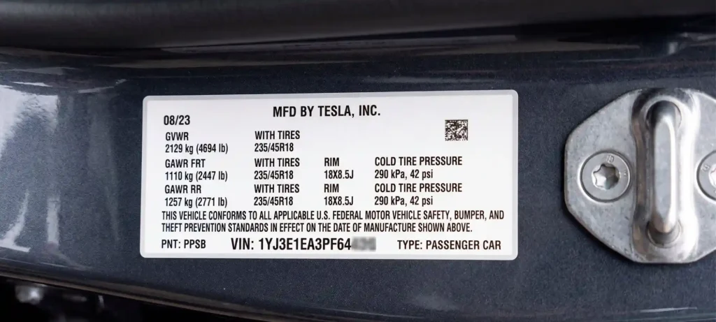 vehicle manufacturer plate with VIN and specifications on a car door